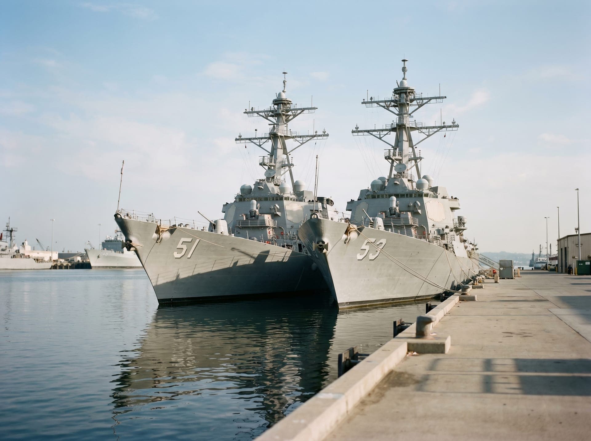 Naval destroyers docked at a military naval base