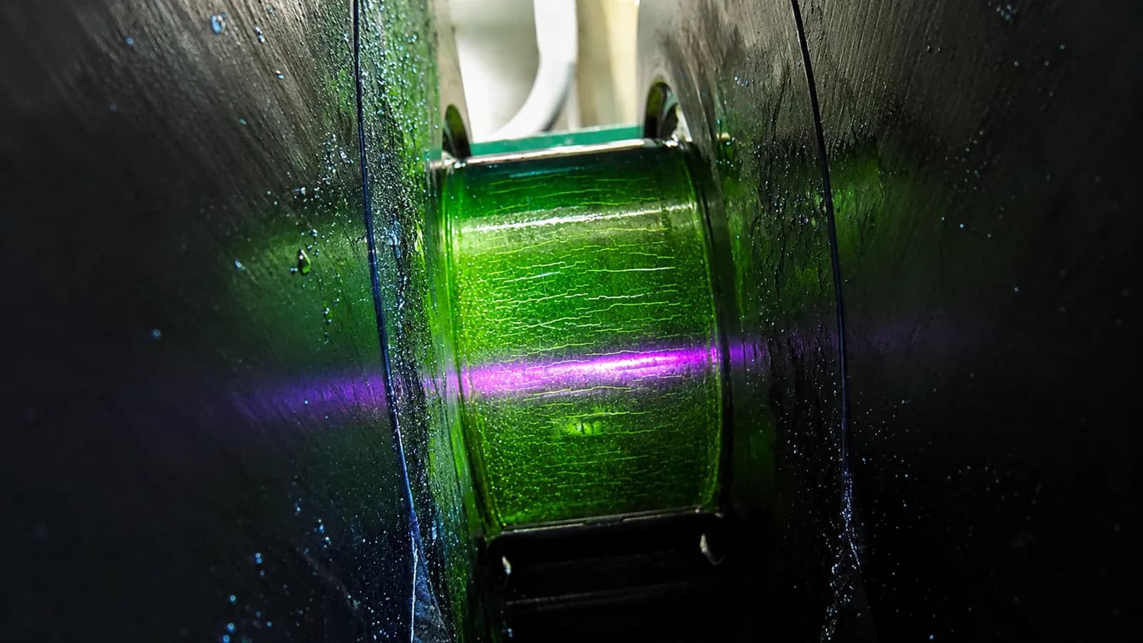 A crankshaft journal examined under ultraviolet light during fluorescent inspection.